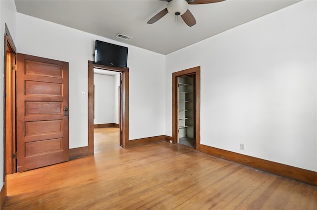 unfurnished bedroom featuring baseboards, a ceiling fan, light wood finished floors, and visible vents