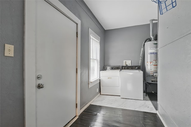 washroom featuring laundry area, a textured wall, water heater, baseboards, and washer and clothes dryer