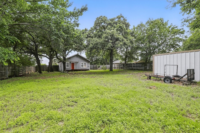 view of yard with an outdoor structure and a fenced backyard