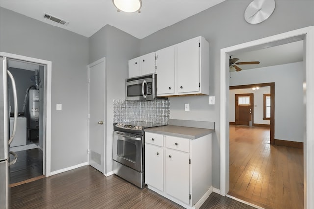 kitchen with ceiling fan, visible vents, baseboards, stainless steel appliances, and dark wood-type flooring