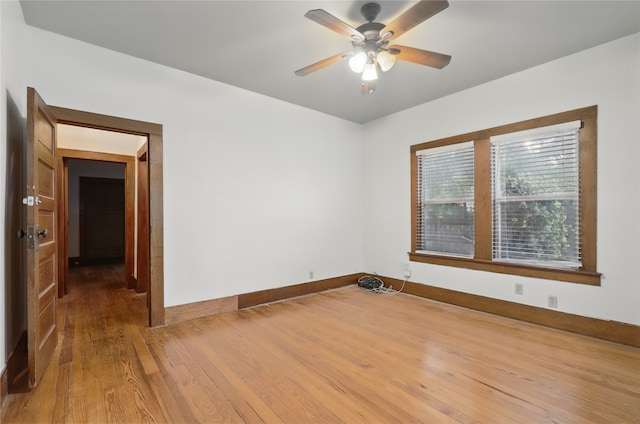 unfurnished room with baseboards, a ceiling fan, and wood finished floors