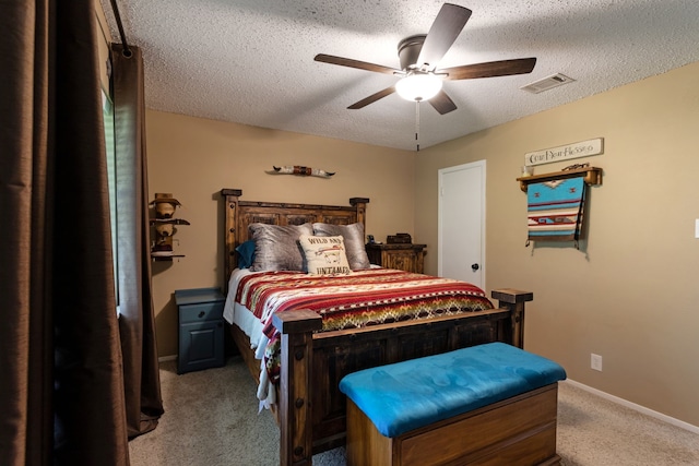 carpeted bedroom with a ceiling fan, a textured ceiling, visible vents, and baseboards