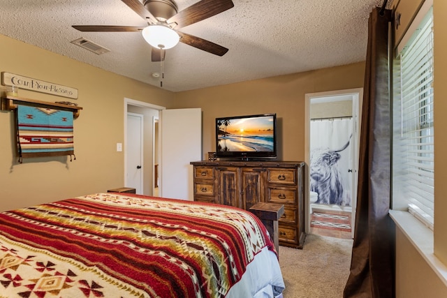 carpeted bedroom with visible vents, a ceiling fan, and a textured ceiling