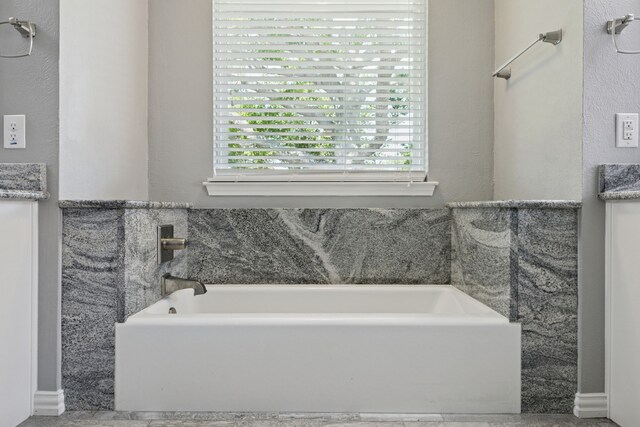 full bath featuring a garden tub and vanity
