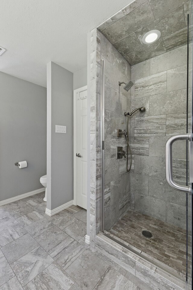 full bathroom featuring toilet, baseboards, visible vents, and a stall shower