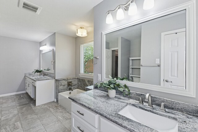 full bath with a sink, two vanities, a bath, and visible vents