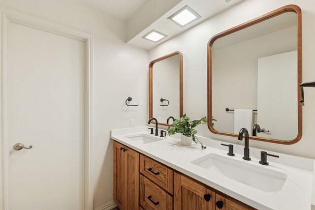 bathroom featuring a sink and double vanity