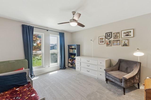 bedroom featuring baseboards, multiple windows, light carpet, and a ceiling fan