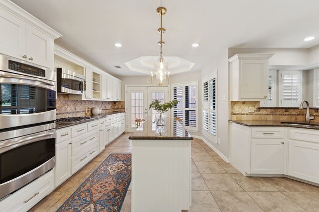 kitchen with a center island, a sink, tasteful backsplash, and stainless steel appliances