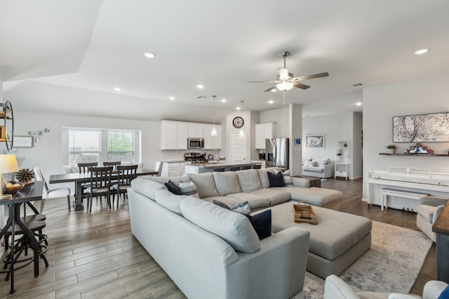 living room with recessed lighting, a ceiling fan, and light wood-style flooring