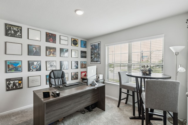 carpeted home office featuring baseboards