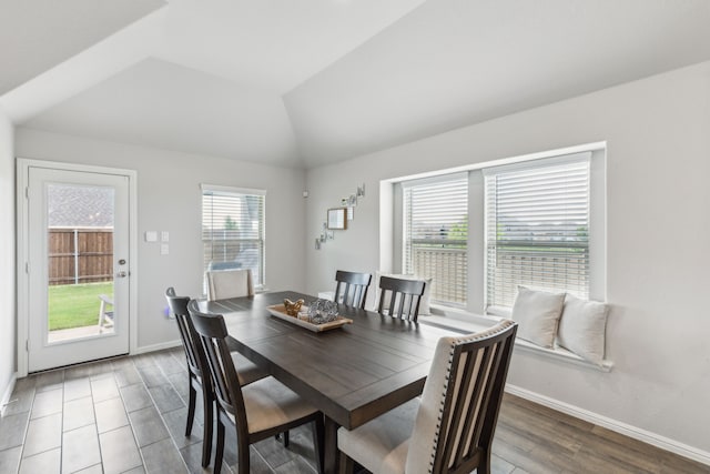 dining area featuring baseboards, vaulted ceiling, and wood finished floors
