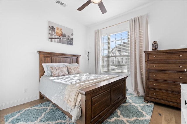 bedroom with visible vents, light wood-style floors, ceiling fan, and baseboards
