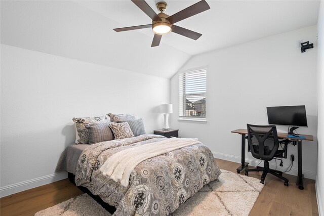 bedroom with a ceiling fan, baseboards, wood finished floors, and lofted ceiling