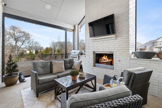 view of patio / terrace featuring exterior kitchen, fence, an outdoor living space with a fireplace, and a grill