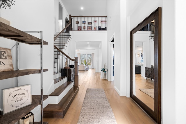 entryway featuring a high ceiling, wood finished floors, and stairway