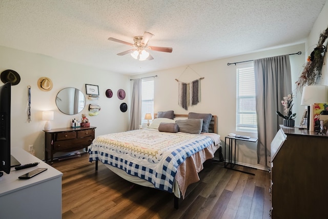 bedroom with a ceiling fan, a textured ceiling, and dark wood-type flooring