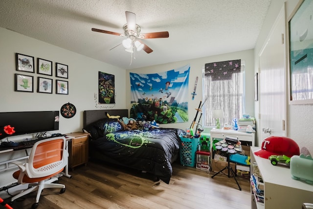 bedroom featuring a textured ceiling, ceiling fan, and wood finished floors