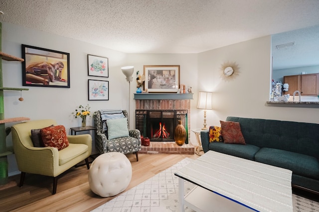 2624 Rockport Ln, Little Elm, TX 75068 - living room featuring wood finished floors, a textured ceiling, and a fireplace