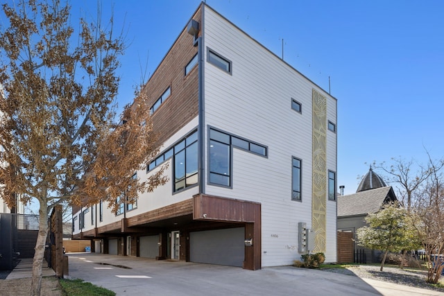 back of property with an attached garage and concrete driveway