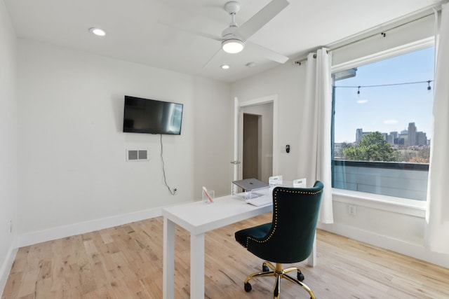 office featuring visible vents, a ceiling fan, baseboards, and light wood-style floors