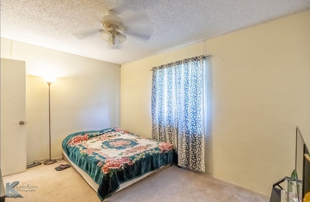 carpeted bedroom featuring a textured ceiling and ceiling fan