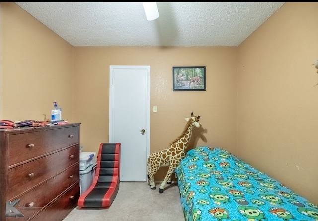 bedroom with a textured ceiling and light colored carpet