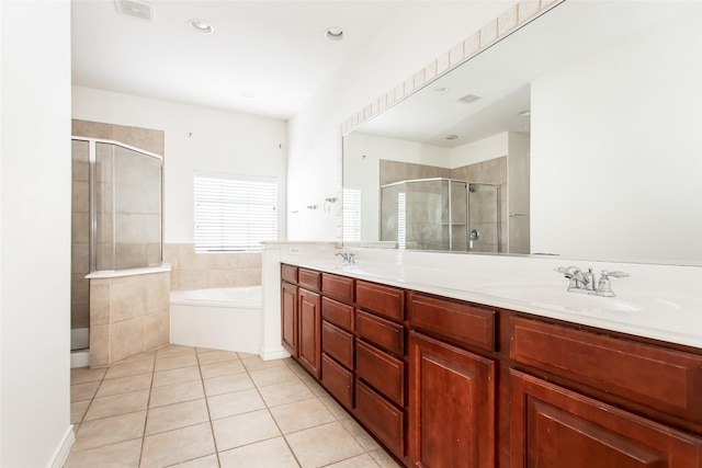 full bath featuring double vanity, a bath, tile patterned floors, a shower stall, and a sink