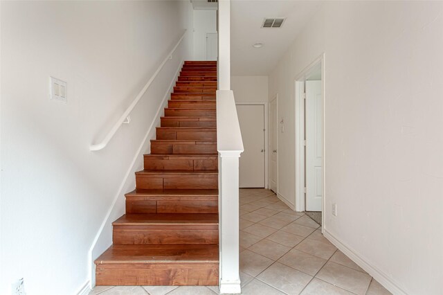 stairway with tile patterned floors and visible vents