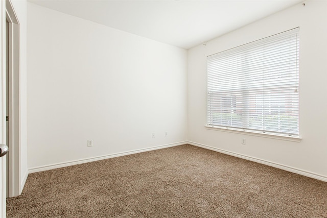 carpeted empty room with baseboards
