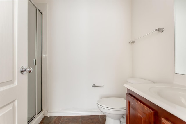 full bathroom with vanity, baseboards, a shower stall, and toilet