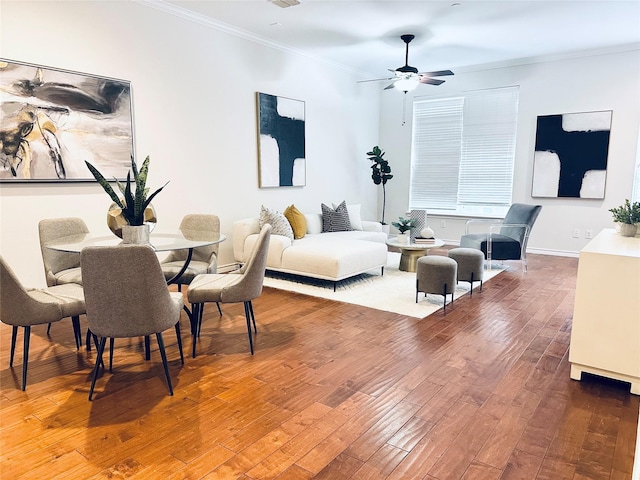 living room with crown molding, a ceiling fan, baseboards, and wood finished floors