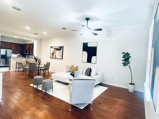 living room featuring recessed lighting, ornamental molding, baseboards, and wood finished floors