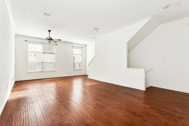 unfurnished living room with ceiling fan, wood-type flooring, baseboards, visible vents, and ornamental molding
