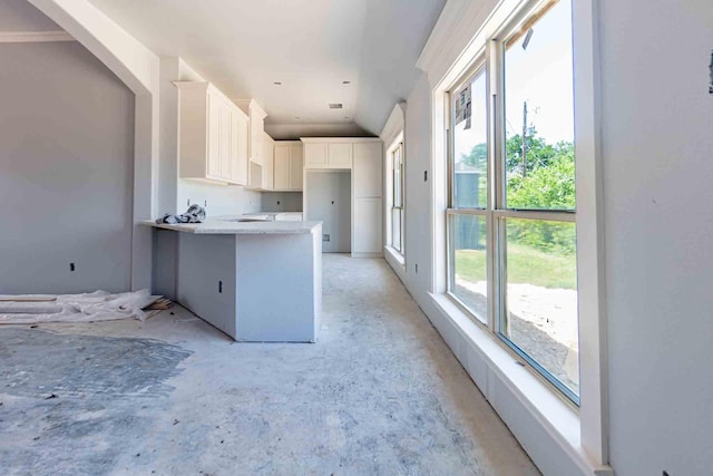 3406 Woodlake Dr, Granbury, TX 76048 - kitchen featuring arched walkways, white cabinetry, and a peninsula