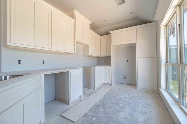 3406 Woodlake Dr, Granbury, TX 76048 - kitchen with stone counters, white cabinetry, and lofted ceiling