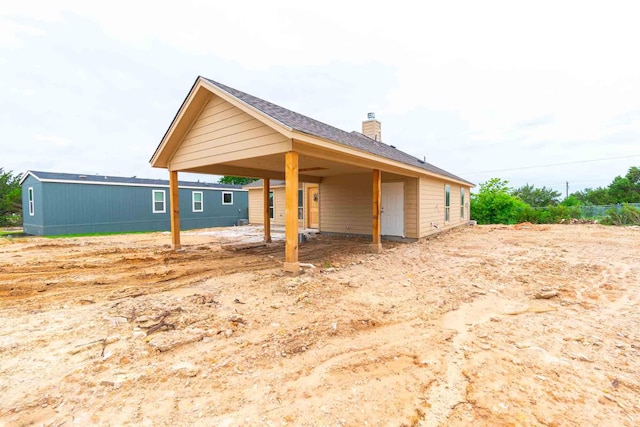 3406 Woodlake Dr, Granbury, TX 76048 - view of side of property with a chimney and a carport