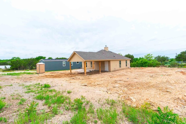3406 Woodlake Dr, Granbury, TX 76048 - rear view of property with a storage shed, a chimney, and an outdoor structure