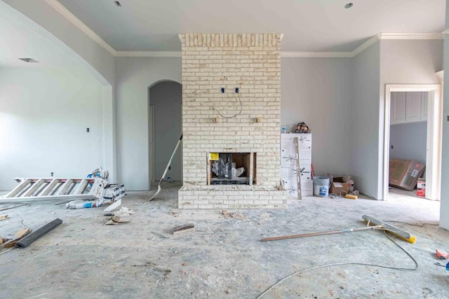 3406 Woodlake Dr, Granbury, TX 76048 - unfurnished living room featuring crown molding, arched walkways, and a brick fireplace