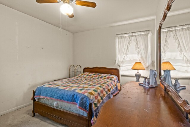 carpeted bedroom featuring baseboards and a ceiling fan
