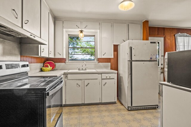 kitchen featuring stainless steel electric range oven, a sink, light countertops, freestanding refrigerator, and under cabinet range hood