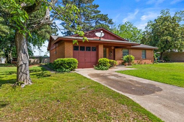 view of front of house with fence, brick siding, a garage, a front yard, and driveway