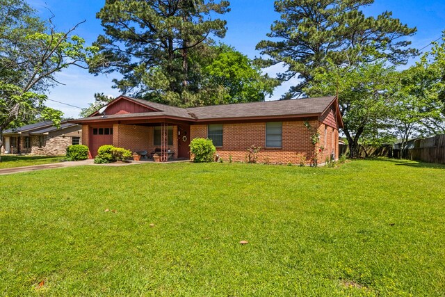 single story home featuring concrete driveway, fence, a front yard, and a garage