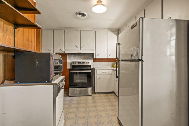kitchen featuring stainless steel electric range, open shelves, freestanding refrigerator, under cabinet range hood, and visible vents