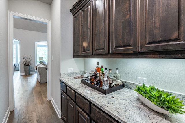 bar featuring baseboards, a dry bar, and wood finished floors