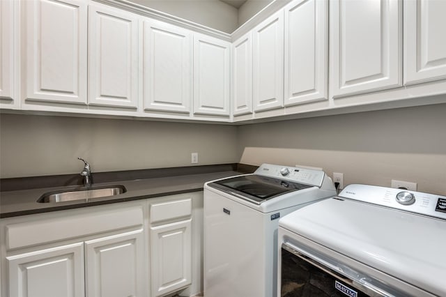 laundry room featuring a sink, separate washer and dryer, and cabinet space