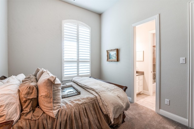carpeted bedroom with baseboards, multiple windows, and ensuite bathroom