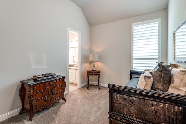 sitting room with baseboards, light colored carpet, and vaulted ceiling