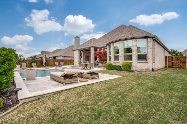 rear view of property with a fenced backyard, a patio, a lawn, and brick siding