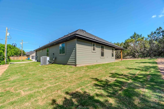 view of side of property featuring a lawn and central air condition unit